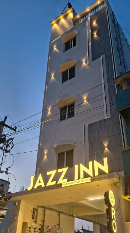 a tall building with a sign on it at Jazz Inn in Tiruvallūr