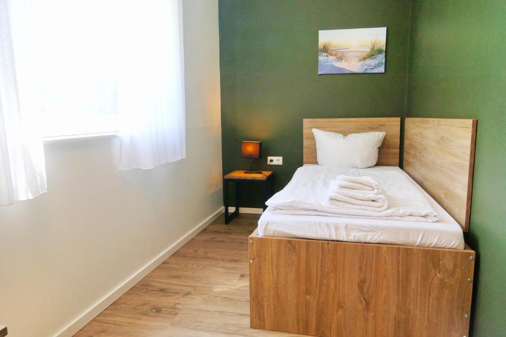 a bed with a wooden frame in a room at Gästehaus Gothensee in Heringsdorf