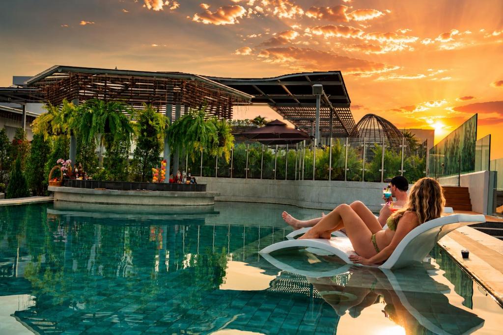 two people sitting in a pool at a resort at Koulen Central Premier Suites in Siem Reap