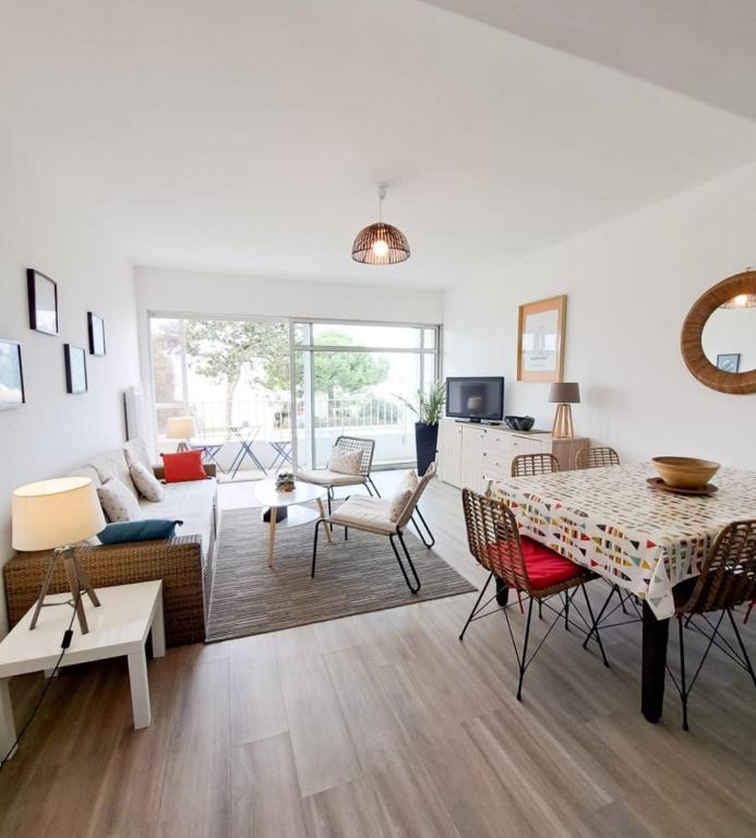 a living room with a table and chairs at L'Océanic in Saint-Georges-de-Didonne