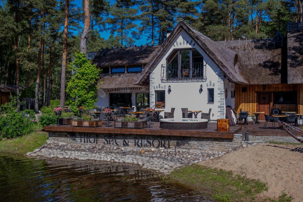 a house with a deck next to a body of water at Metsatiigi Resort in Kersalu