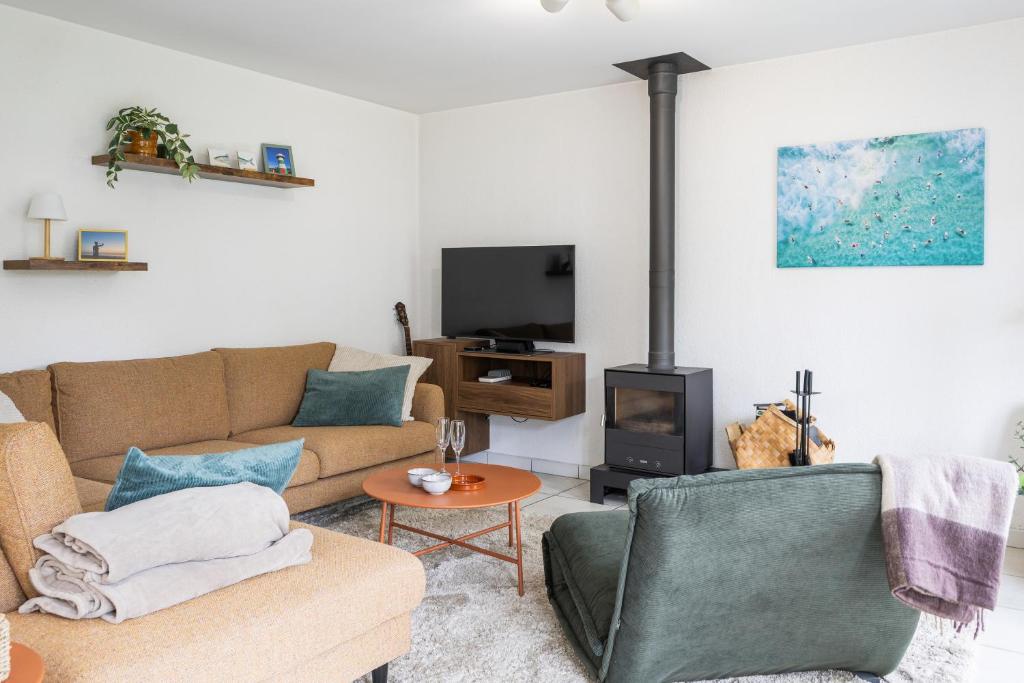 a living room with a couch and a tv at Sea Side Village 91 in De Haan