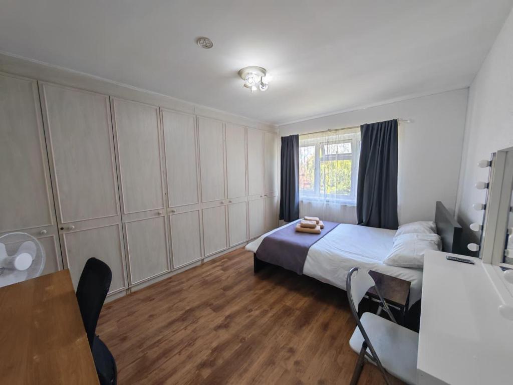 a bedroom with a bed and a table and chairs at Spacious Double Room with Shared Bathroom in London