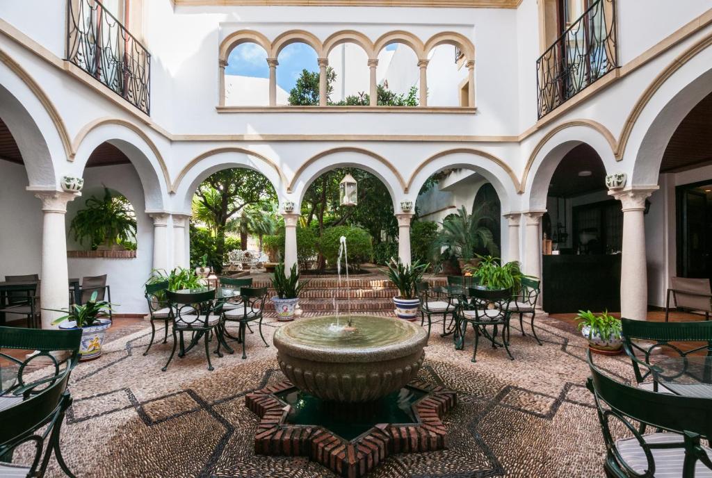 a courtyard with a fountain and tables and chairs at Eurostars Conquistador in Córdoba