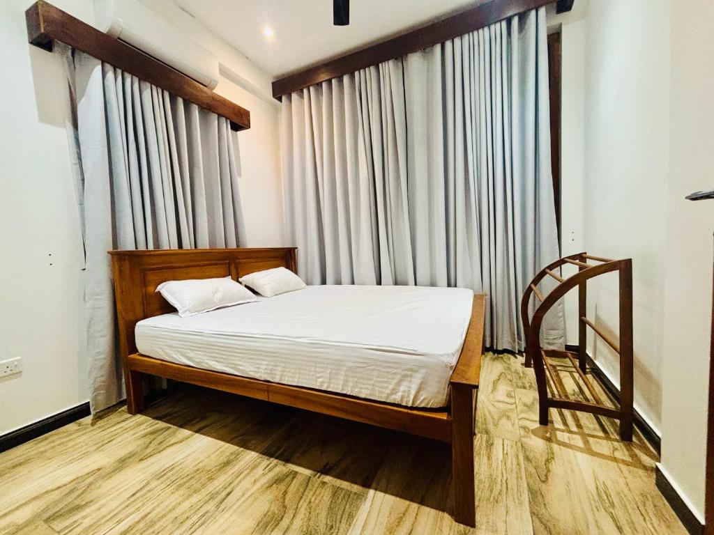 a bedroom with a bed and a large window at SB Guest in Trincomalee