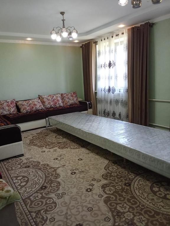 a large bed in a room with a couch at Rest Hous Adis in Kyzart