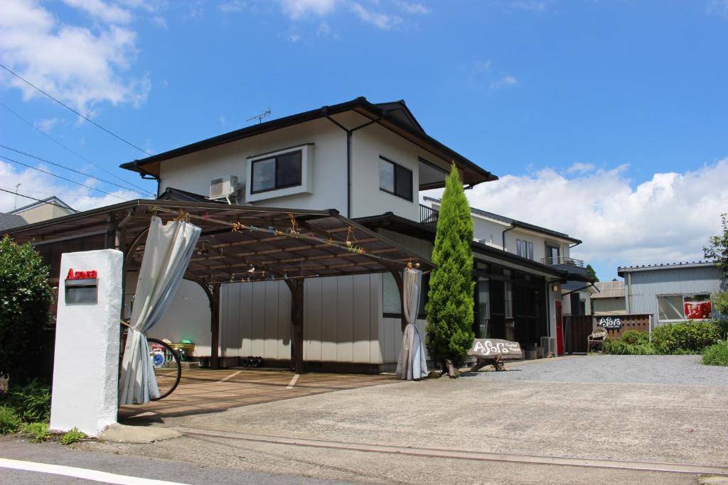 a house with awning in front of a driveway at Guest House Asora in Aso