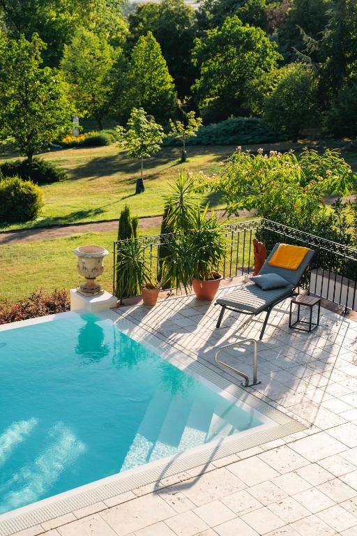 a swimming pool with a chair next to a fence at Scharioth Birtok in Nagyréde