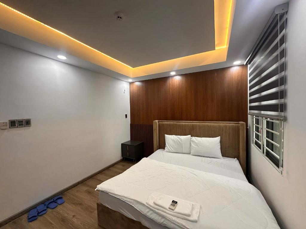 a bedroom with a large bed with a wooden headboard at Căn hộ Na Uy in Nha Trang