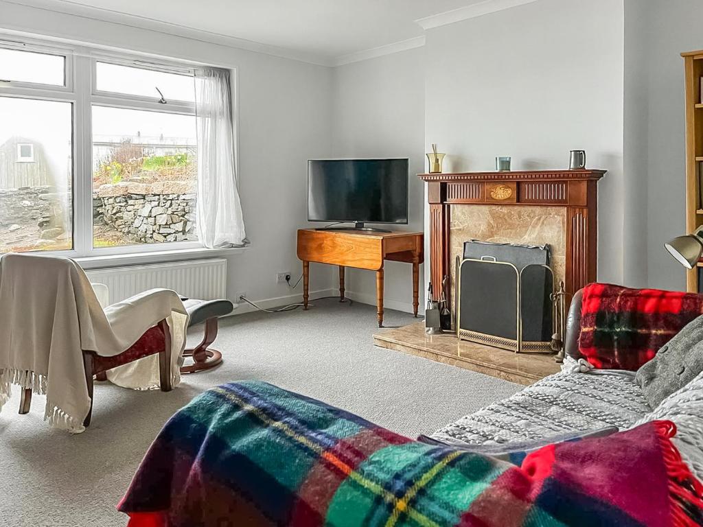 a living room with a fireplace and a tv at The Anchorage in Collieston