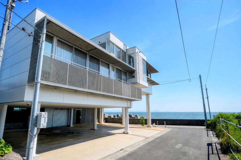 an apartment building with the ocean in the background at VillaMer KAWACHI in Kumamoto