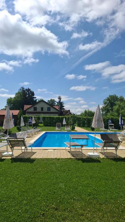 a pool with chairs and a table and a house at Casa cu Prispa in Sighişoara