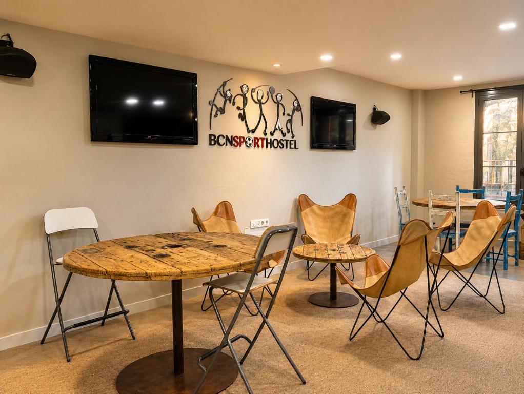 a room with a table and chairs and a tv at BcnSportHostels in Barcelona