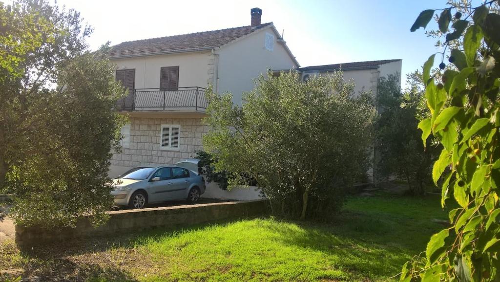a car parked in front of a white house at inKorcula in Korčula