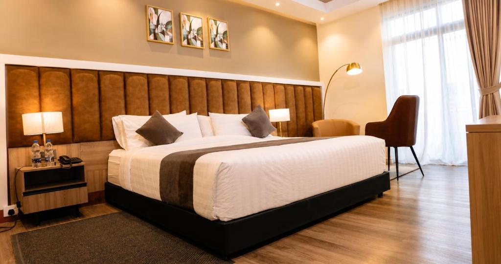 a hotel room with a large bed and a chair at Ras Hotel - Harar in Hārer