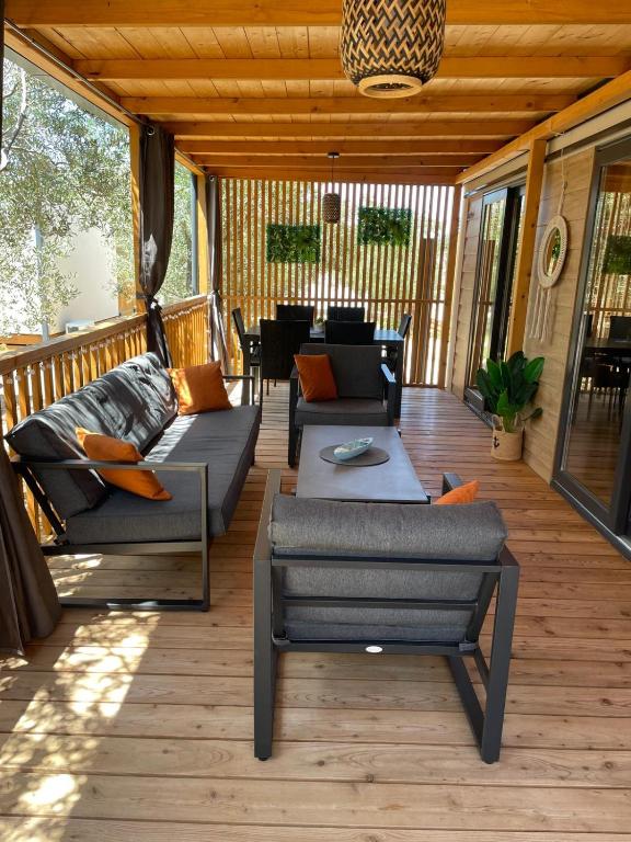 a patio with couches and a table on a deck at Mobile Home Drage Tara in Drage