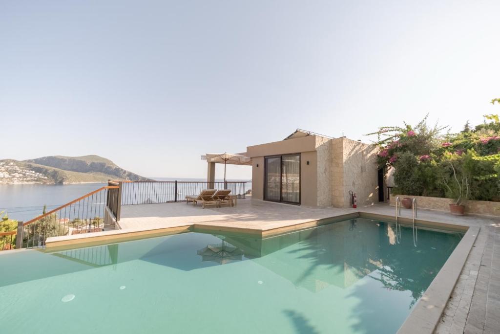 a house with a swimming pool with a view of the water at Asfiya Sea View Hotel in Kalkan