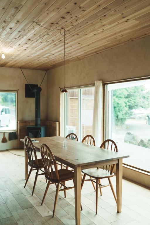 ein Esszimmer mit einem Holztisch und Stühlen in der Unterkunft 一棟貸しヴィラmatai in Kitsuki