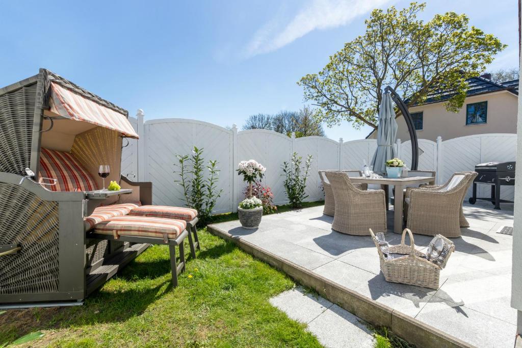 a backyard with a table and chairs and a fence at Ferienhaus Ostseeperle in Zingst