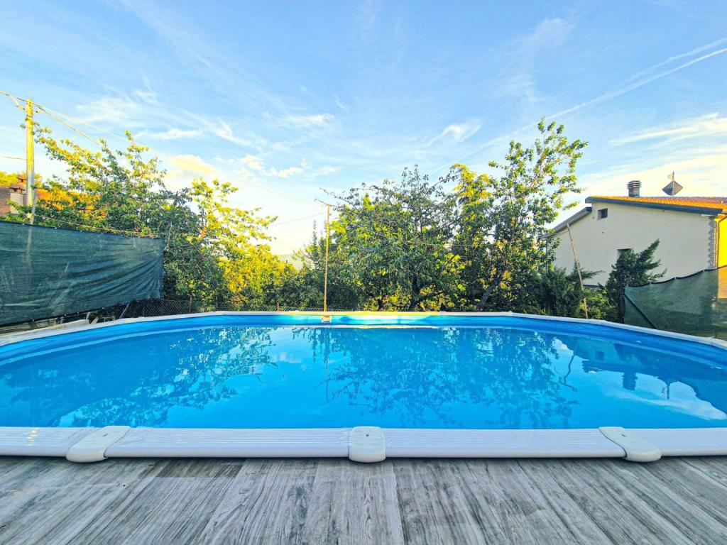 a large blue swimming pool on a wooden deck at Ca di Borra - Orto Bio e Piscina in Rofelle