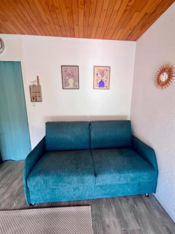a couch in a room with a wooden ceiling at Studio cosy avec balcon et vue sur la montagne à Chamrousse - 19 m² in Chamrousse