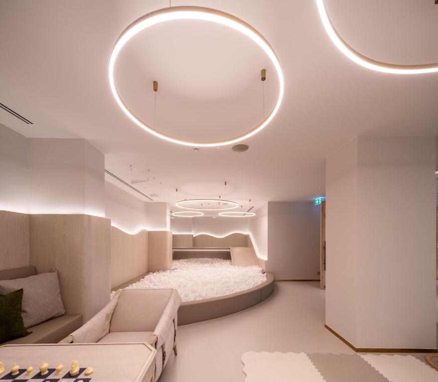 A softly lit lounge with curved built-in seating, sofas, and a playful circular design.