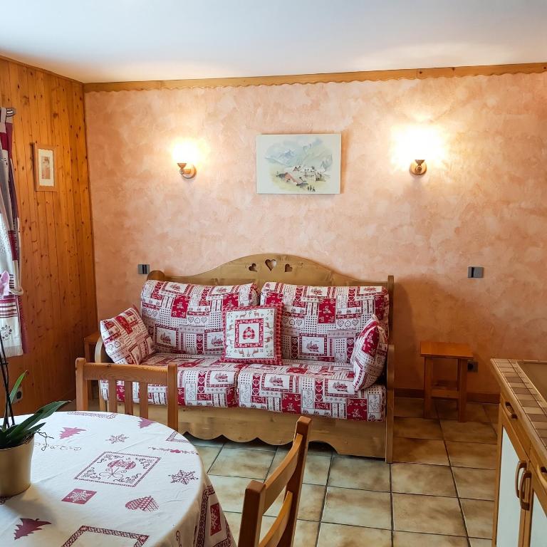 a living room with a table and a couch with pillows at Studio cosy à Les Gets 25 m² avec vue montagne in Les Gets
