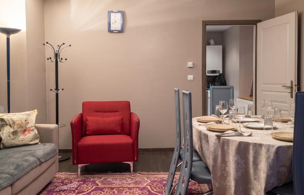 a dining room with a table and a red chair at Appartement spacieux Gérardmer 90 m² in Gérardmer