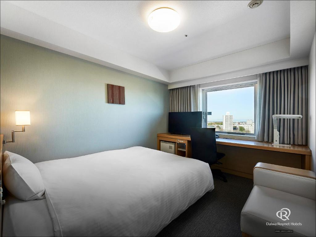 a hotel room with a bed and a desk and a window at Daiwa Roynet Hotel Tsukuba in Tsukuba