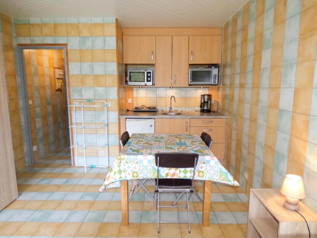 a kitchen with a table and chairs in a room at Studio charmant dans Brioude – 25 m² avec terrasse et parking in Brioude