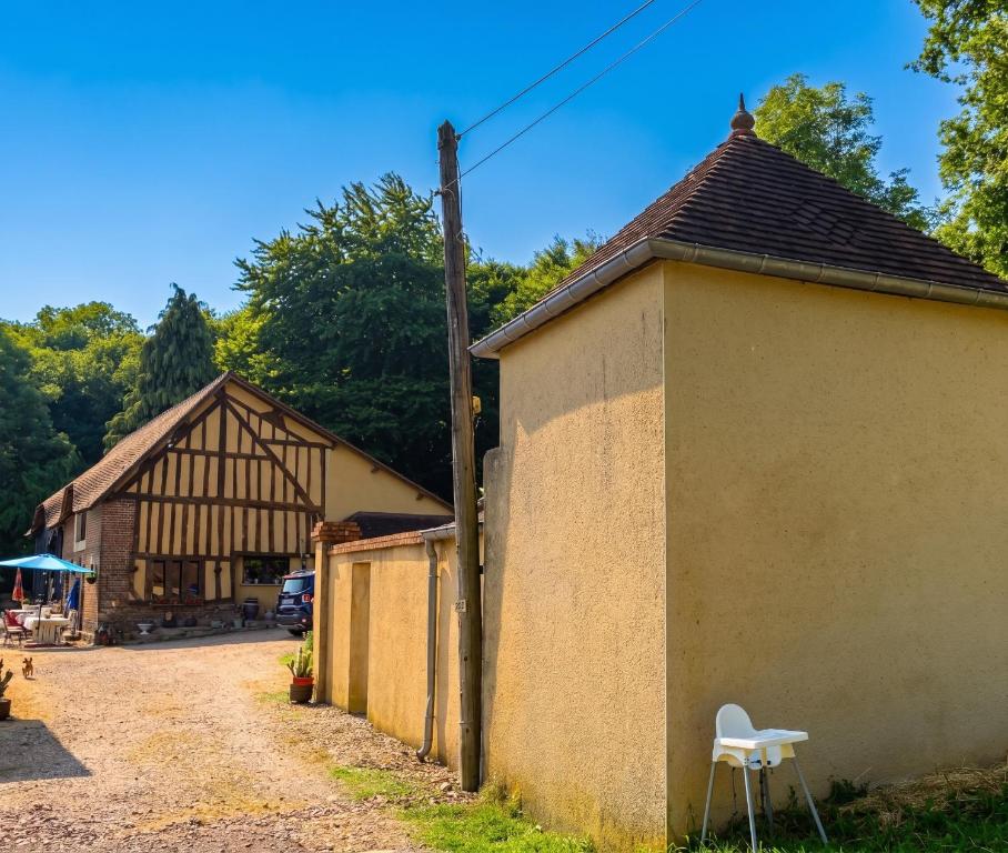 a barn and a building with a chair next to it at Studio cosy à Camembert - 20 m² avec terrasse et parking in Camembert