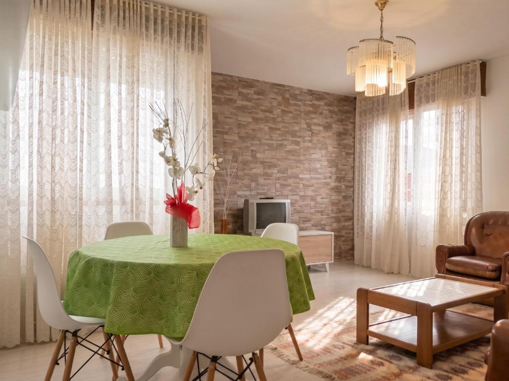 a dining room with a green table and white chairs at Welcoming Apartment in A Coruña, 90 m², Balcony in Serres