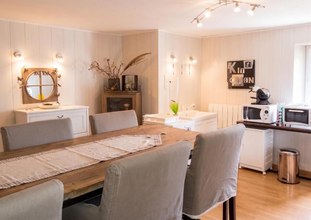 a dining room with a wooden table and chairs at Appartement spacieux à Chenevrey-et-Morogne 160 m² avec terrasse in Chenevrey-et-Morogne