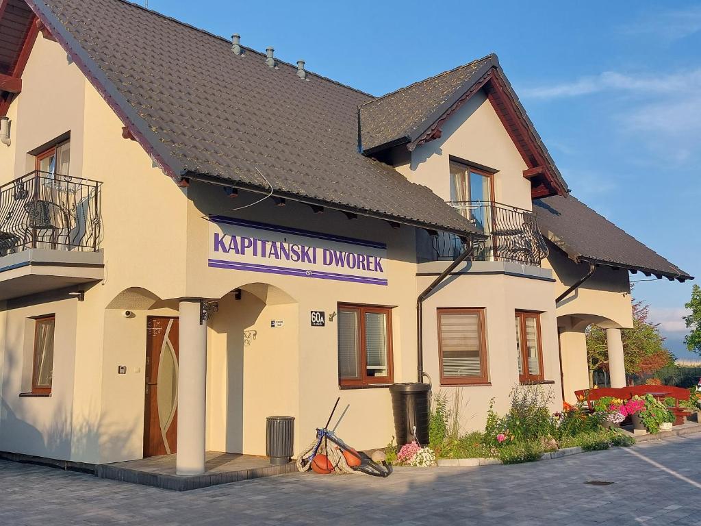 a building with a sign for ayrwegian divorce at Kapitański Dworek in Krynica Morska