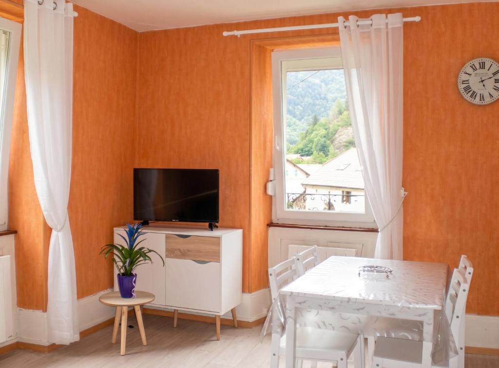 a dining room with a table and a window at Appartement charmant à Plancher-les-Mines 40 m² avec jardin in Plancher-les-Mines