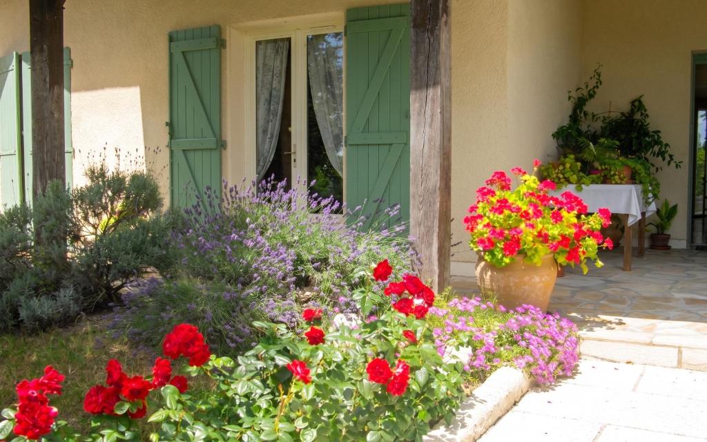 a garden of flowers in front of a house at Appartement avec piscine à Montpezat-de-Quercy 40 m² in Montpezat-de-Quercy