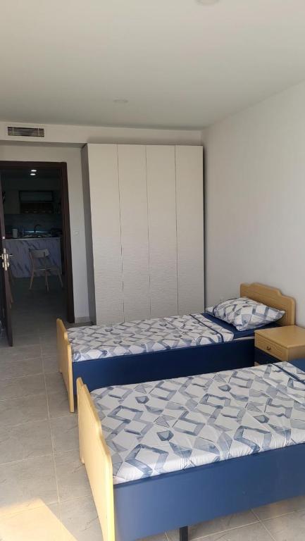 a bedroom with two beds and a dining room at F3 résidence nid d'abeille in Bejaïa