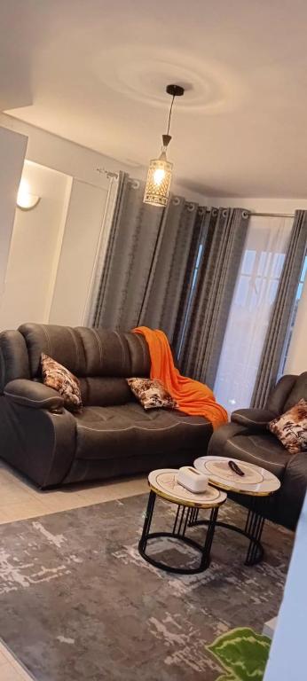 un soggiorno con un divano e due tavoli di The Amber Homes a Meru
