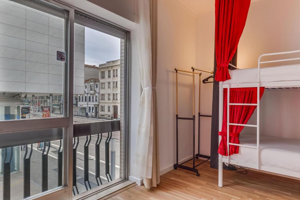a room with a balcony with a bed and a window at Avenue View Rooms in Porto