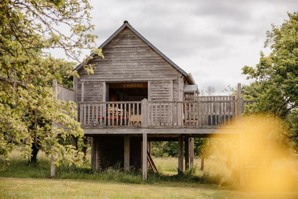 a house with a deck and a balcony at Cabane Pomme d'Amour in La Chapelle-Bouexic