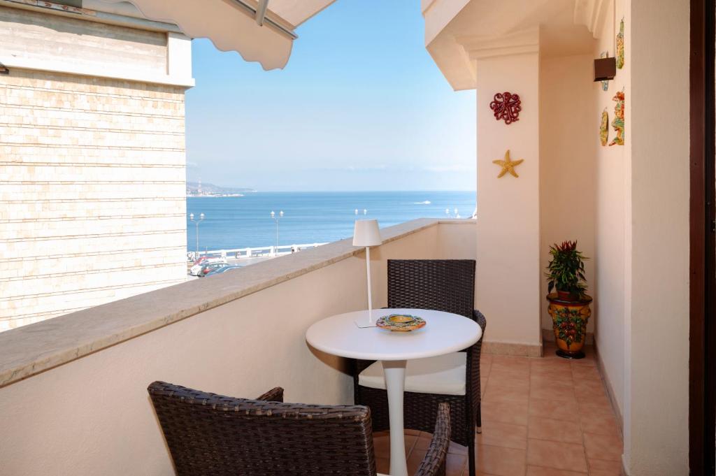 a balcony with a table and a view of the ocean at The Square - Luxury Apartment in Scilla