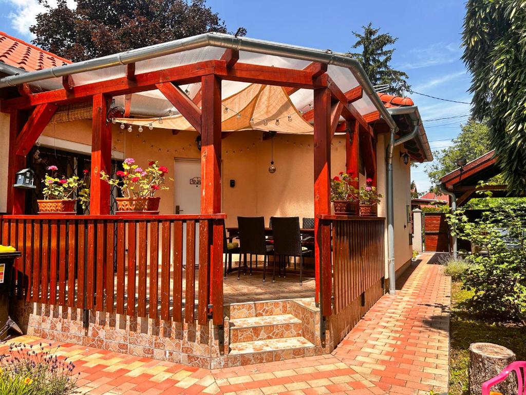 a wooden pergola on a house with a patio at Lily House in Balatonvilágos
