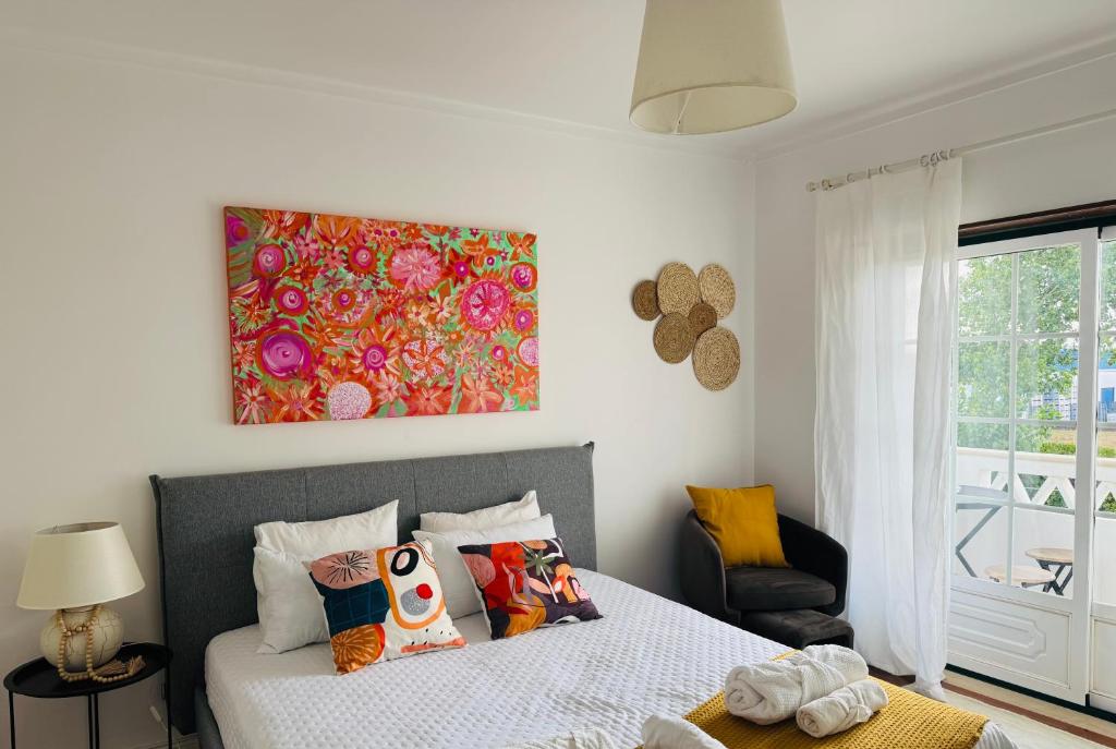 a bedroom with a bed and a painting on the wall at The Yellow Retreat in A dos Cunhados