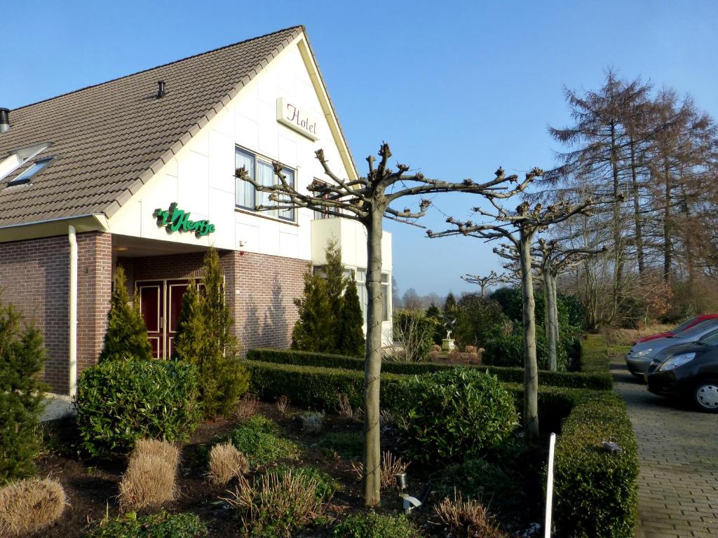 a building with a tree in front of it at Hotel Restaurant Het Roode Hert in Dalfsen