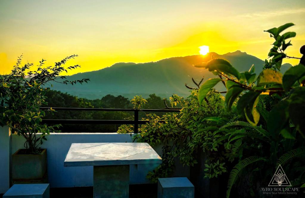a view of the sunset from a balcony with a bench at Aybo Soulscape Villa Dambulla in Dambulla