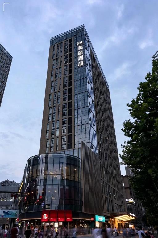 a tall building with people standing in front of it at Mercure Xian North in Xi'an