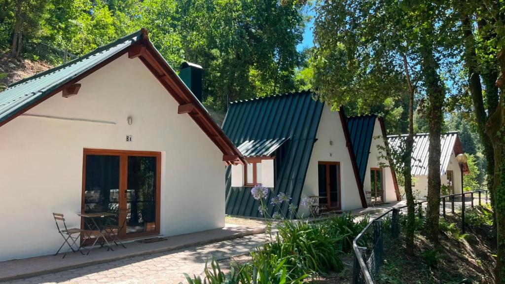a small white house with a green roof at Bungalow Refúgio do Pezo T1 in Melgaço