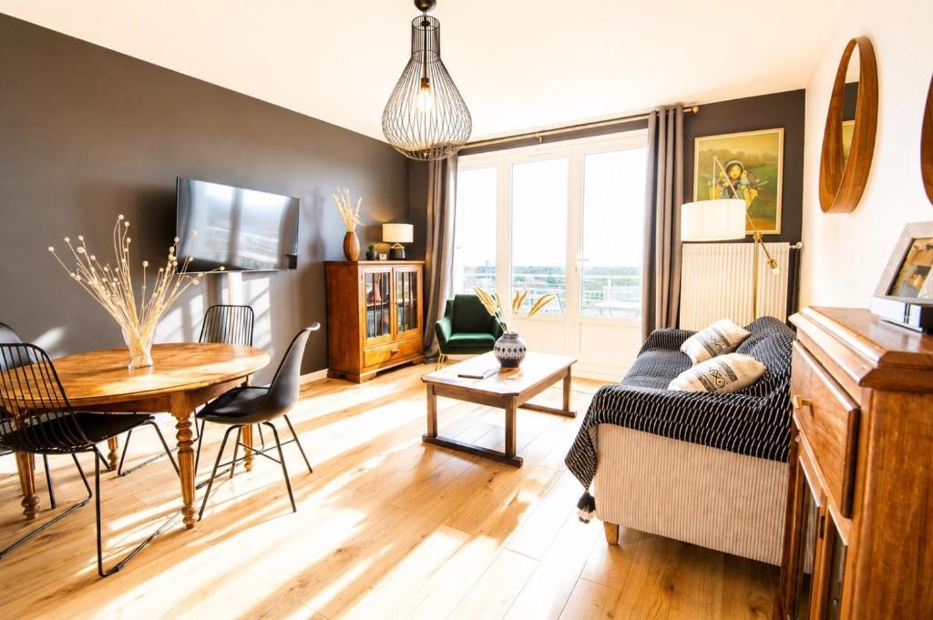 a living room with a couch and a table at Black and White - Joli appart à Tours in Joué-lès-Tours
