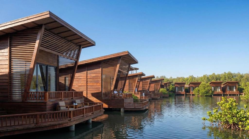 a row of wooden houses on a river at Lagoona Eco Resort Binh Chau in Binh Chau