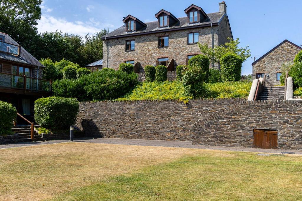 a large brick house on top of a stone wall at Keepers Cottage - Dartmouth Golf and Spa Resort in Dartmouth